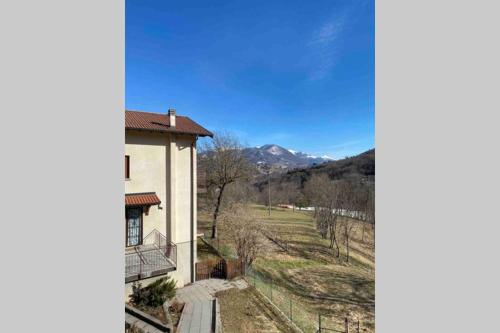 a house with a balcony and a view of a field at Lanzo D'Intelvi “LA MARINELLA” in Lanzo dʼIntelvi