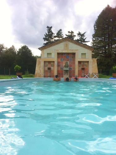 une grande piscine avec un bâtiment en arrière-plan dans l'établissement Château De Chambiers, à Durtal