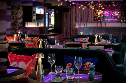 a restaurant with wine glasses on a table at NYX Hotel London Holborn by Leonardo Hotels in London