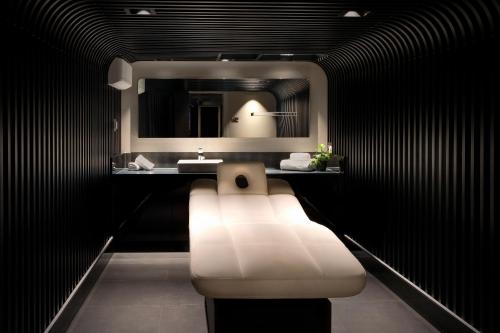 a bathroom with a white bench in front of a sink at NYX Hotel London Holborn by Leonardo Hotels in London