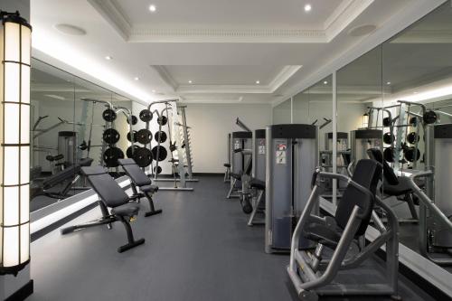 a gym with rows of tread machines and mirrors at NYX Hotel London Holborn by Leonardo Hotels in London