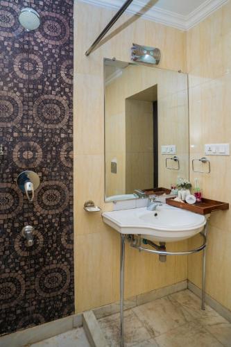 a bathroom with a sink and a mirror at Ganga Heritage - By The Palm Bliss Resort in Haridwār