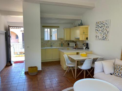 a kitchen and living room with a table and a couch at Au bord de la mer in Cavalaire-sur-Mer