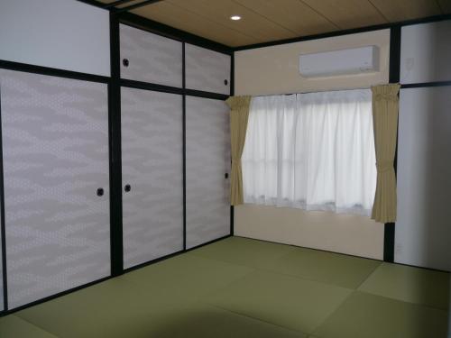 una camera con porte scorrevoli in vetro e finestra di 江津良別邸 a Shirahama