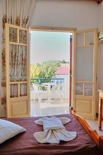 a bedroom with a bed and a sliding glass door at Tria Adelphia in Arillas