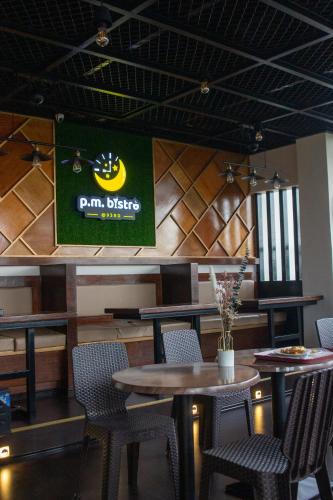 a restaurant with tables and chairs and a sign on the wall at A.M @ 93rd HOTEL in Olongapo