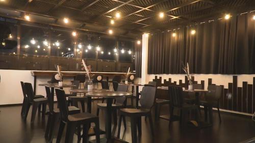 a dining room with tables and chairs and lights at A.M @ 93rd HOTEL in Olongapo