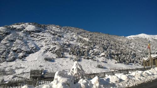 a mountain covered in snow with trees on it at Hotel Roc de St Miquel & Apartment in Soldeu