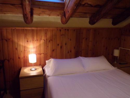 a bedroom with a bed with a lamp on a night stand at Hotel Roc de St Miquel & Apartment in Soldeu