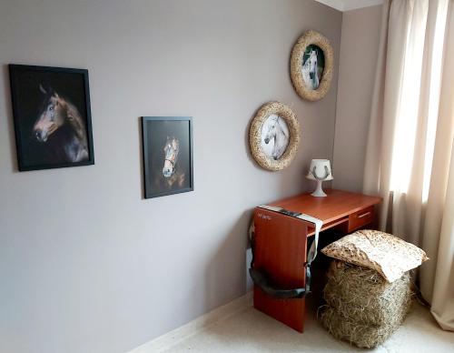 a room with a desk and pictures of a horse on the wall at Centrum Turystyczno- Rehabilitacyjne in Krzyżewo