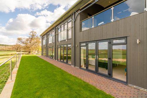 an exterior view of a building with windows and grass at Lower Lodge Barn in Alcester