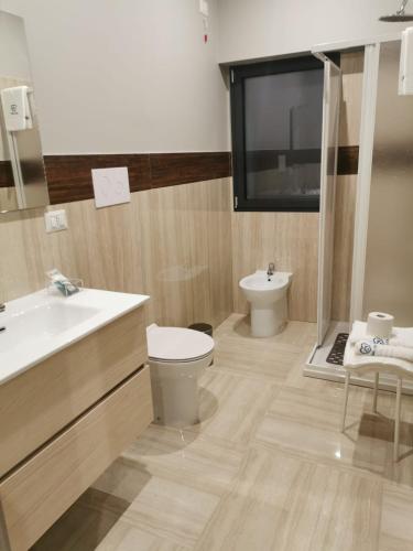 TV y baño con lavabo y aseo. en Casa Mia1, en Foggia