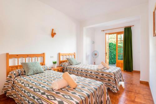 two beds in a room with a window at Brisa Mar 1, 2 bedroom apartment, Cala'n Bosch in Son Xoriguer