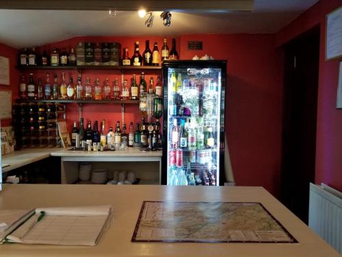 een bar met een koelkast met flessen alcohol bij Glenan Lodge Self Catering in Tomatin