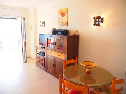Un comedor con una mesa y un televisor. en MIRAMAR 23A, en Roses