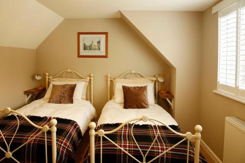 two beds in a room with a attic at The Dog House, Penryn in Penryn