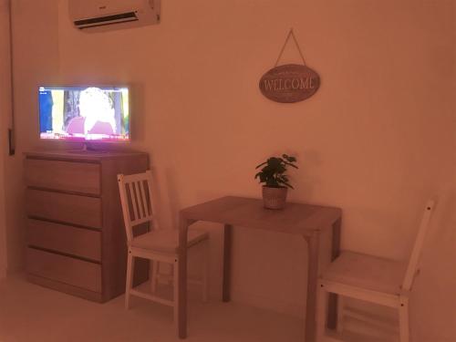 a dining room with a table and chairs and a tv at Magenta in Monopoli