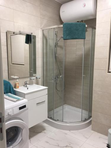 a bathroom with a glass shower and a sink at Bugibba Sunrise View Modern Apartment in St. Paul's Bay