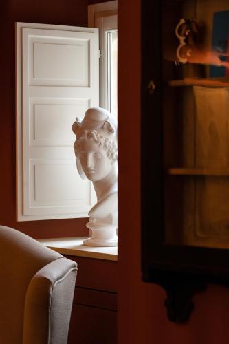 a statue sitting on a shelf next to a window at Q92 Noto in Noto