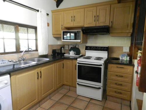 a kitchen with a white stove and a microwave at Fairways Holiday Accommodation in Drakensberg Garden