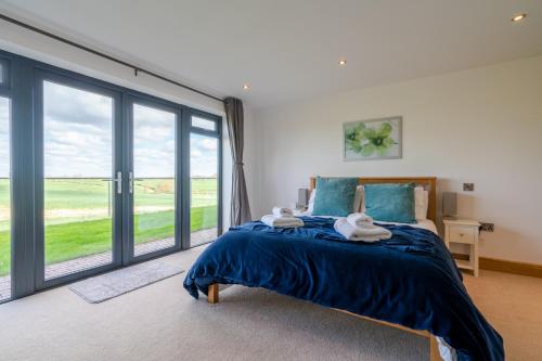 a bedroom with a bed and a large window at Lower Lodge Barn in Alcester