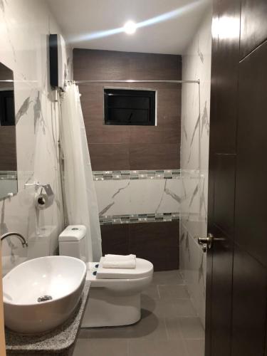 ein Badezimmer mit einem weißen WC und einem Waschbecken in der Unterkunft A.M @ 93rd HOTEL in Olongapo