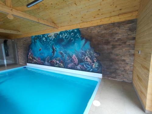 a swimming pool in a room with a painting on the wall at Willa Karo dom bliźniak 7-osobowy ZE STREFĄ BASENOWĄ w miejscowości Chocznia NIEDALEKO ZATORU I ENERGYLANDII in Chocznia