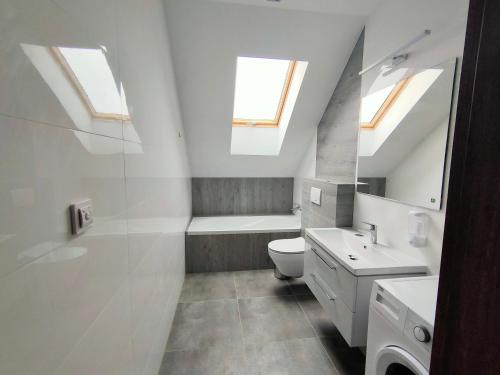 a bathroom with a toilet and a sink and skylights at Willa Karo dom bliźniak 7-osobowy ZE STREFĄ BASENOWĄ w miejscowości Chocznia NIEDALEKO ZATORU I ENERGYLANDII in Chocznia