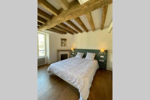 a bedroom with a bed in a room with wooden floors at La mystérieuse maison du Robimouth in Saint-Satur
