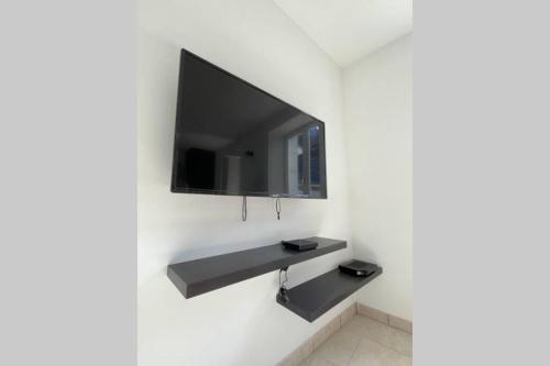 a flat screen tv hanging on a wall at La mystérieuse maison du Robimouth in Saint-Satur