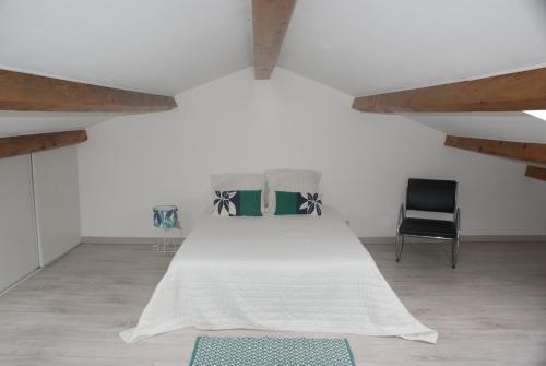 a bedroom with a bed and two chairs at maly appart avec balcon et 1 studio en rez-de-chaussée in Vedène