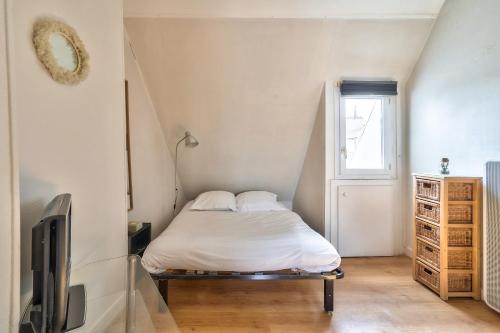 - une petite chambre avec un lit et une télévision dans l'établissement New Parisian Studio with View in the Central 11th, à Paris