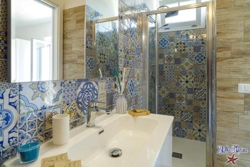 y baño con lavabo y ducha con espejo. en Quasi in Porto Rooms en Castellabate
