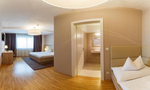 a hotel room with two beds and a mirror at Pfeiler's Bürgerstüberl - Hotel in Feldbach