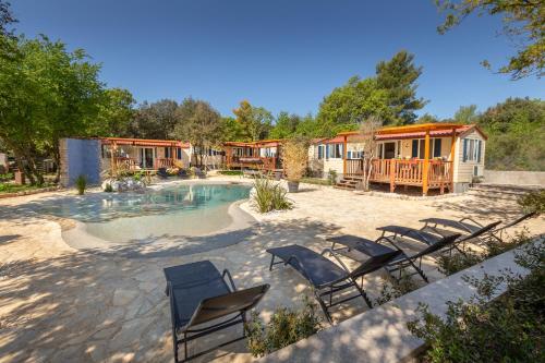 a group of chairs sitting around a swimming pool at Mobile Homes Camp Green Garden Veštar in Rovinj