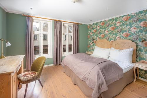 a bedroom with a bed and a desk and window at GamlaVærket Gjæstgiveri og Tracteringssted in Sandnes