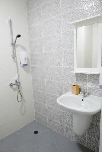 a white bathroom with a sink and a mirror at Къща за гости „Ботаника“ in Nadarevo