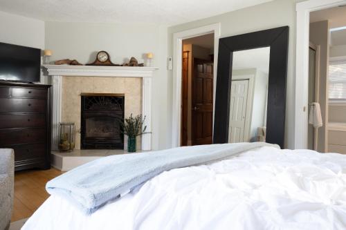 a bedroom with a white bed and a fireplace at Private Berkshire Escape Special April Pricing select your dates for discount Monthly Pricing in Lee