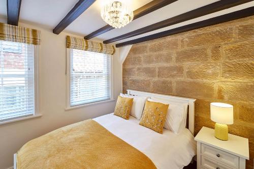 a bedroom with a bed and two windows at Host & Stay - Thimble Cottage in Whitby
