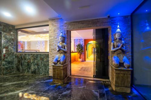 a lobby with two statues on the wall at GRAND KOLİBRİ PRESTİGE in Konaklı