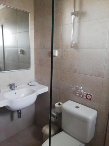 a bathroom with a sink and a toilet and a mirror at ASTRA Village Resort in Svoronata