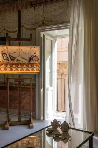 a room with a glass table and a window at Q92 Noto in Noto