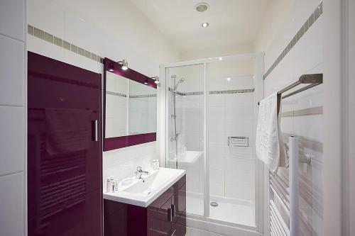 une salle de bain blanche avec un lavabo et une douche dans l'établissement Sunlight Properties - 