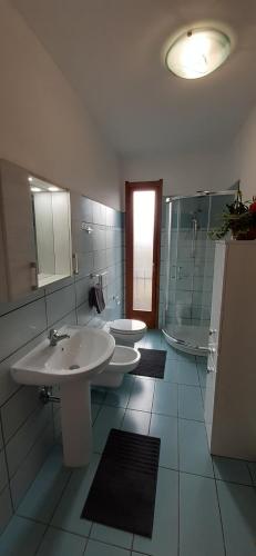 een badkamer met 2 wastafels, een douche en 2 toiletten bij Casa Cao Appartamento "L'Ulivo" in Nurachi