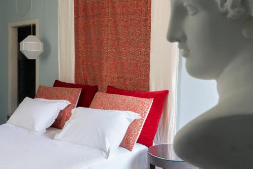 a bedroom with a bed with red and white pillows at Q92 Noto in Noto