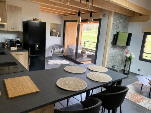 Il comprend une cuisine équipée d'une table avec 4 chaises et d'un réfrigérateur. dans l'établissement Gîte cosy, au calme entre Genève et Annecy, à Viuz-en-Sallaz