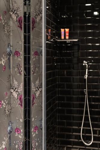 a shower in a bathroom with a brick wall at Q92 Noto in Noto