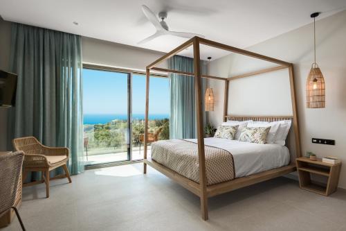 a bedroom with a canopy bed with a view of the ocean at paleo villas in Lákones