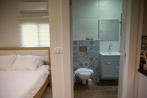 a bedroom with a bed and a sink and a toilet at Adan - Suietes in Majdal Shams