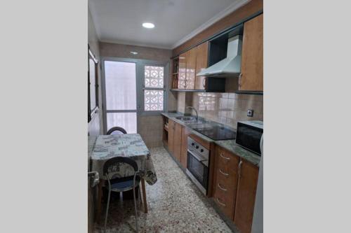 a kitchen with a table and a dining room at Apartamento H9 Gran Playa con vistas al mar in Santa Pola